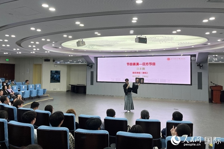 日本大學(xué)生介紹能樂知識。人民網(wǎng)記者 陳思攝