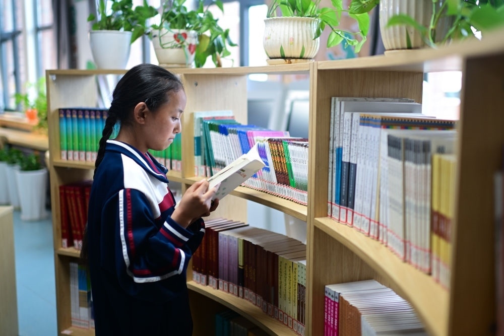 6月18日，果洛西寧民族中學(xué)學(xué)生尼東拉毛在圖書室看書。