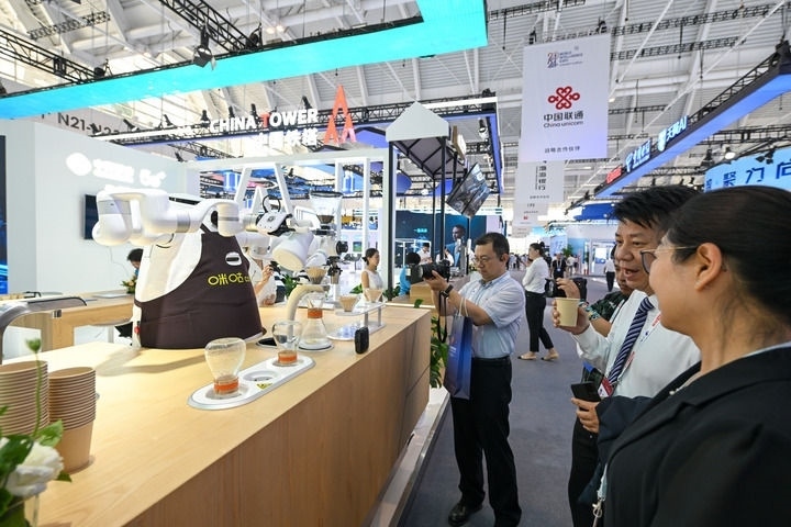 6月20日，與會者品嘗機器人沖調(diào)出的咖啡。新華社記者 孫凡越 攝