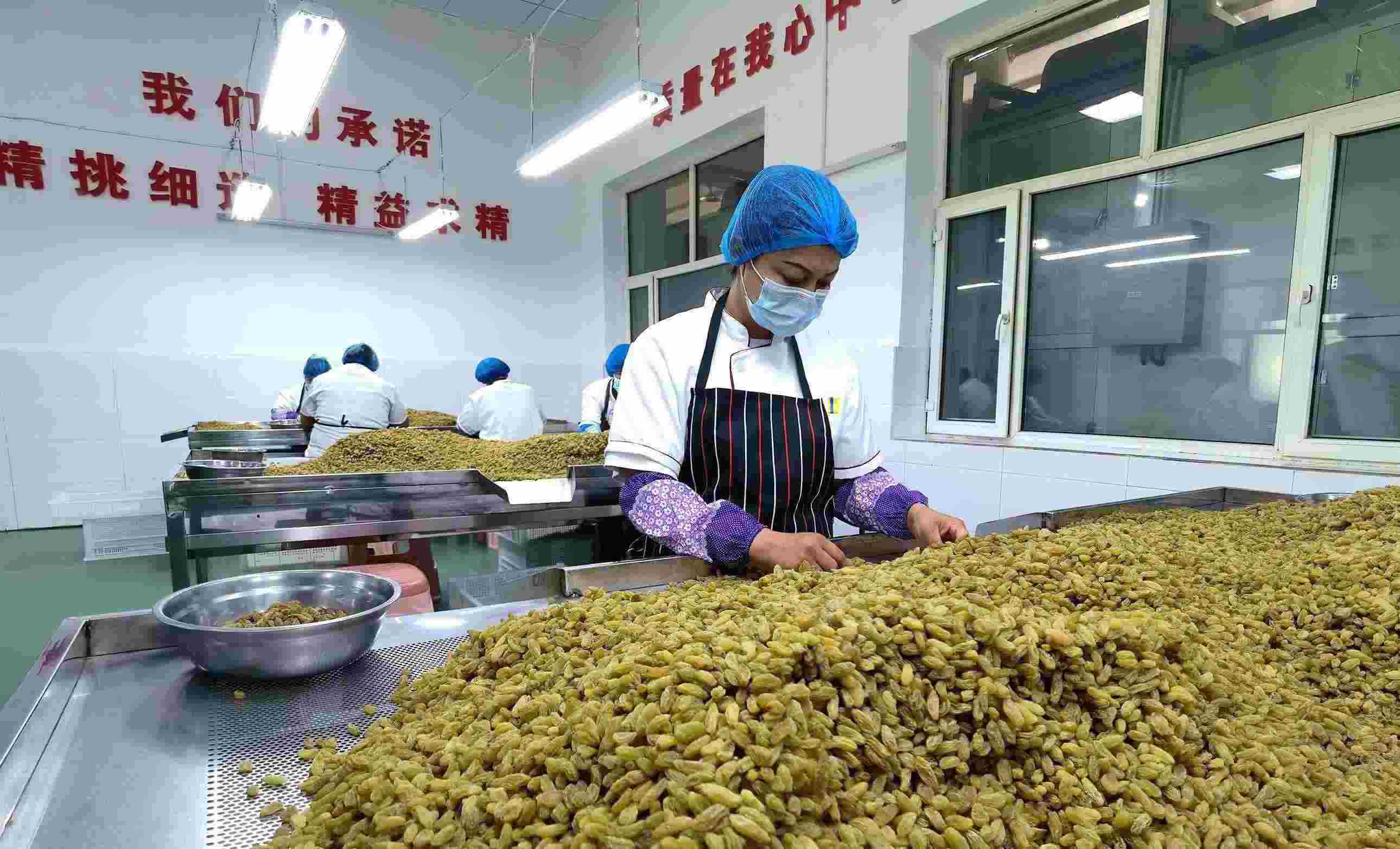 新疆吐魯番市高昌區(qū)亞爾鎮(zhèn)新城西門(mén)村，村民們?cè)诜謷咸迅伞? width=