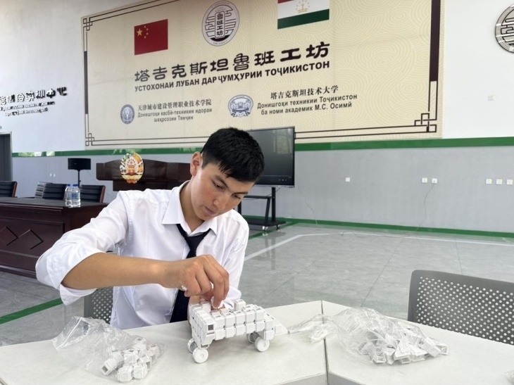 在塔吉克斯坦魯班工坊內(nèi)，學(xué)員正在操作能力源創(chuàng)新套件。本報(bào)記者 屈佩 攝