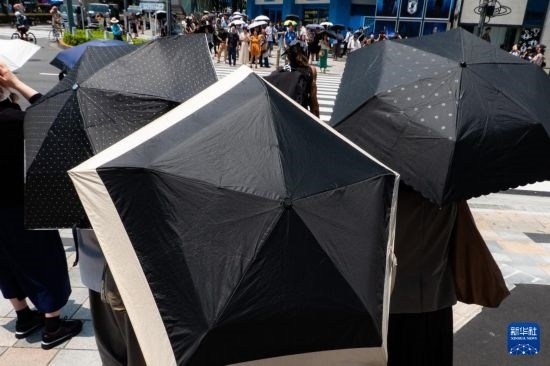 7月4日，人們在日本東京原宿的街道上等待紅綠燈。新華社記者 張笑宇 攝