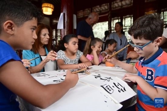 7月4日，在馬耳他桑塔露琪亞市的中國(guó)古典園林“靜園”，人們體驗(yàn)中國(guó)書法。新華社發(fā)（喬納森·博格 攝）