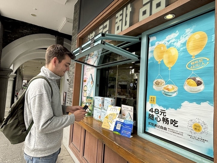 來(lái)自德國(guó)的留學(xué)生理查德在杭州西湖邊一家商鋪使用支付寶掃碼支付（2024年4月11日攝）。新華社發(fā)