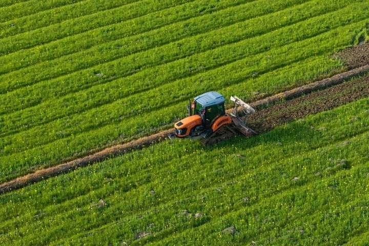 2024年3月19日，在湖南省常德市鼎城區(qū)謝家鋪鎮(zhèn)港中坪村，村民駕駛農(nóng)機翻耕田地（無人機照片）。新華社記者 陳思汗 攝