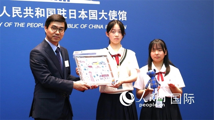 日本小大使向中國駐日本大使館臨時代辦施泳贈送當(dāng)?shù)靥厣Y品。人民網(wǎng) 許可攝