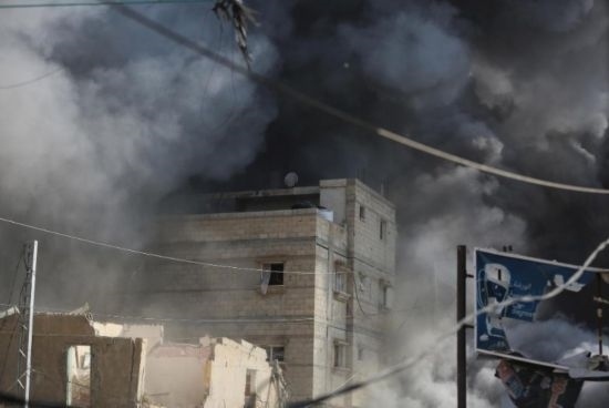 7月21日，在加沙地帶中部的努賽賴特難民營，遭以軍空襲的建筑冒出滾滾濃煙。新華社發(fā)（馬爾萬·達烏德攝）