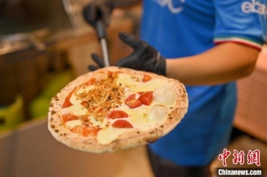 近日，韋榮耀展示他制作的“老友味”披薩。 俞靖 攝