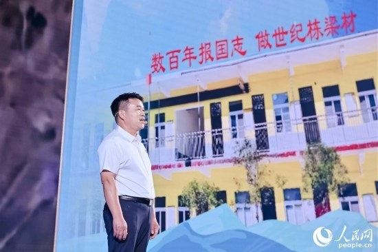 張玉滾分享用一根扁擔(dān)送孩子們走出大山的故事。人民網(wǎng)攝