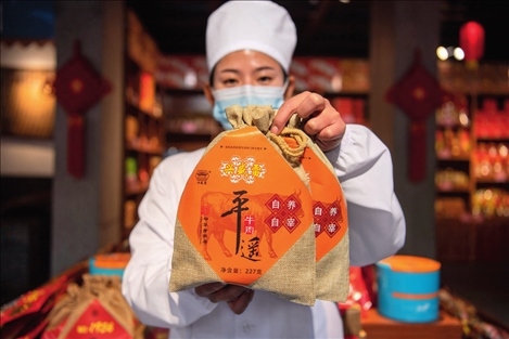 在位于山西省晉中市平遙縣的平遙古城南大街的一家平遙牛肉店內(nèi)，工作人員展示一款牛肉產(chǎn)品（資料照片）楊晨光攝 / 本刊