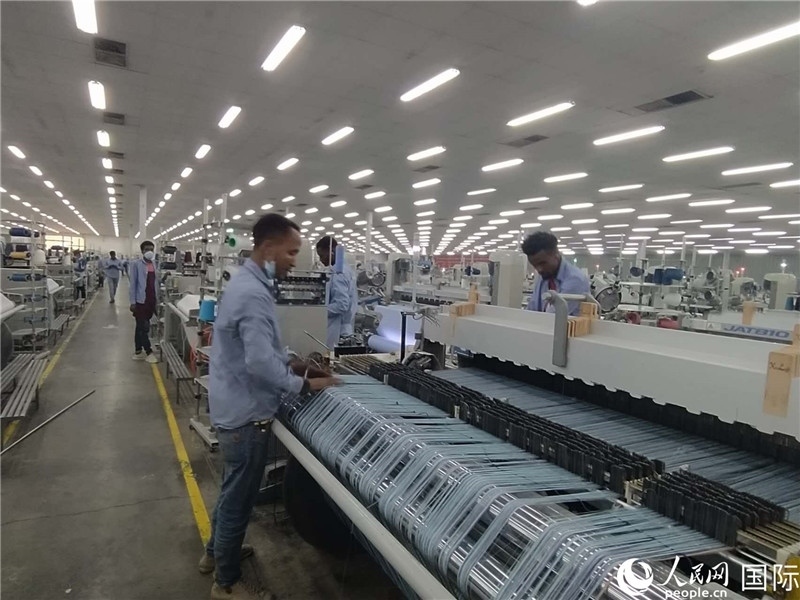 無錫金茂埃塞面料廠車間內(nèi)，當(dāng)?shù)毓と苏谝唤z不茍地作業(yè)。人民網(wǎng)記者 黃培昭攝