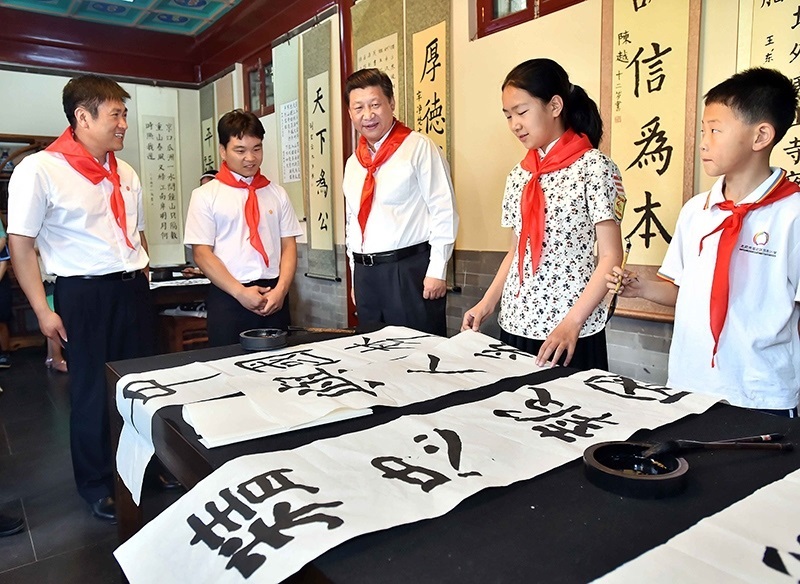 2014年5月30日，習(xí)近平總書記來到北京市海淀區(qū)民族小學(xué)，參加慶?！傲弧眹H兒童節(jié)活動。這是總書記觀看學(xué)生書寫的毛筆字。