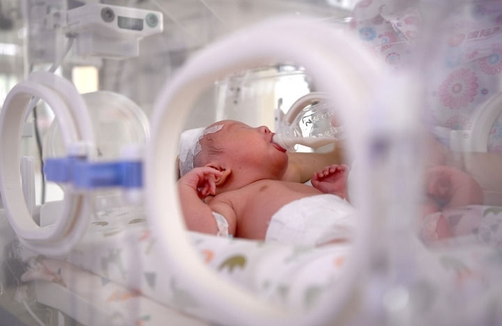 2024年6月1日，在西安國際醫(yī)學(xué)中心醫(yī)院新生兒科病房，護(hù)士為新生兒喂奶。 新華社記者 劉瀟 攝