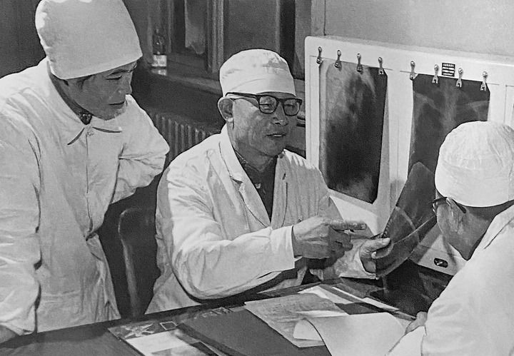 1980年1月16日，中日友好醫(yī)院首任院長辛育齡（中）在內(nèi)蒙古結(jié)核病院與胸外科醫(yī)師討論病例（翻拍照片）。 新華社發(fā)