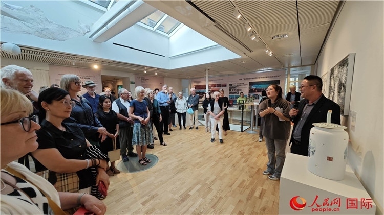 參展人、景德鎮(zhèn)陶瓷大學(xué)美術(shù)學(xué)院副院長邵長宗（右一）向來賓介紹參展作品。人民網(wǎng)記者 殷淼攝