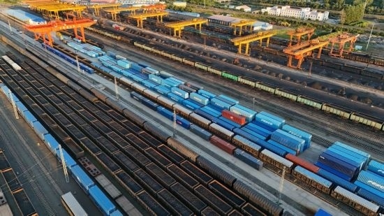 這是2024年8月14日在黑龍江綏芬河鐵路口岸集裝箱換裝場拍攝的集裝箱換裝作業(yè)現(xiàn)場（無人機(jī)照片）。今年前七個(gè)月，綏芬河鐵路口岸開行中歐班列573列，運(yùn)量達(dá)55246標(biāo)箱，同比分別增長23%和18%，班列數(shù)量持續(xù)保持高位運(yùn)行。