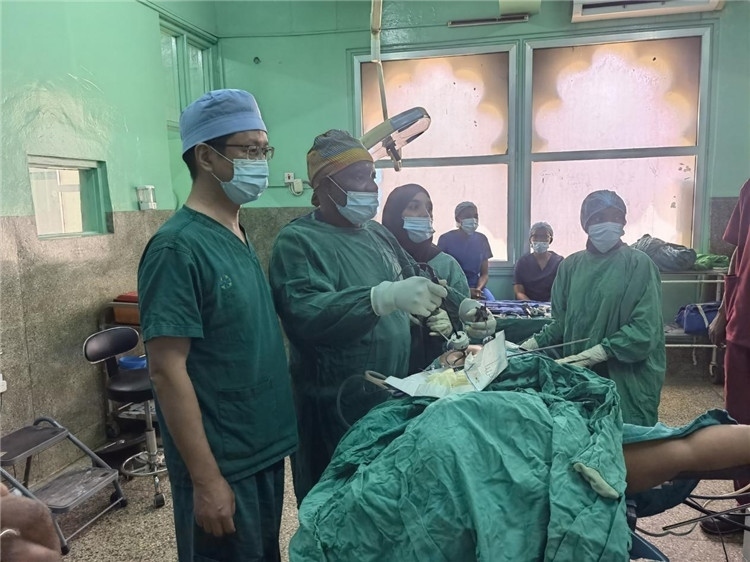 隊(duì)長蔣國慶（左一）關(guān)注當(dāng)?shù)蒯t(yī)生手術(shù)情況。中國援桑醫(yī)療隊(duì)供圖