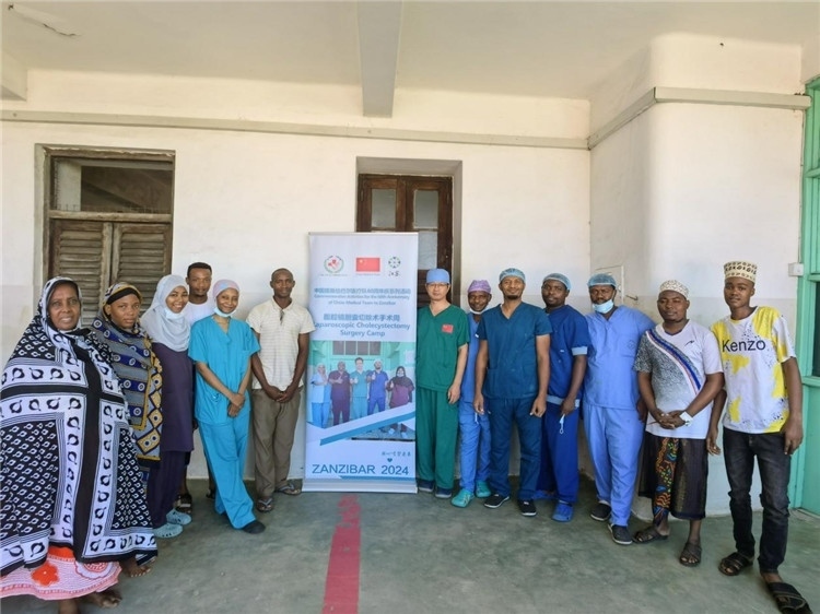 隊(duì)長蔣國慶（右七）和手術(shù)醫(yī)生、部分患者合影。中國援桑醫(yī)療隊(duì)供圖