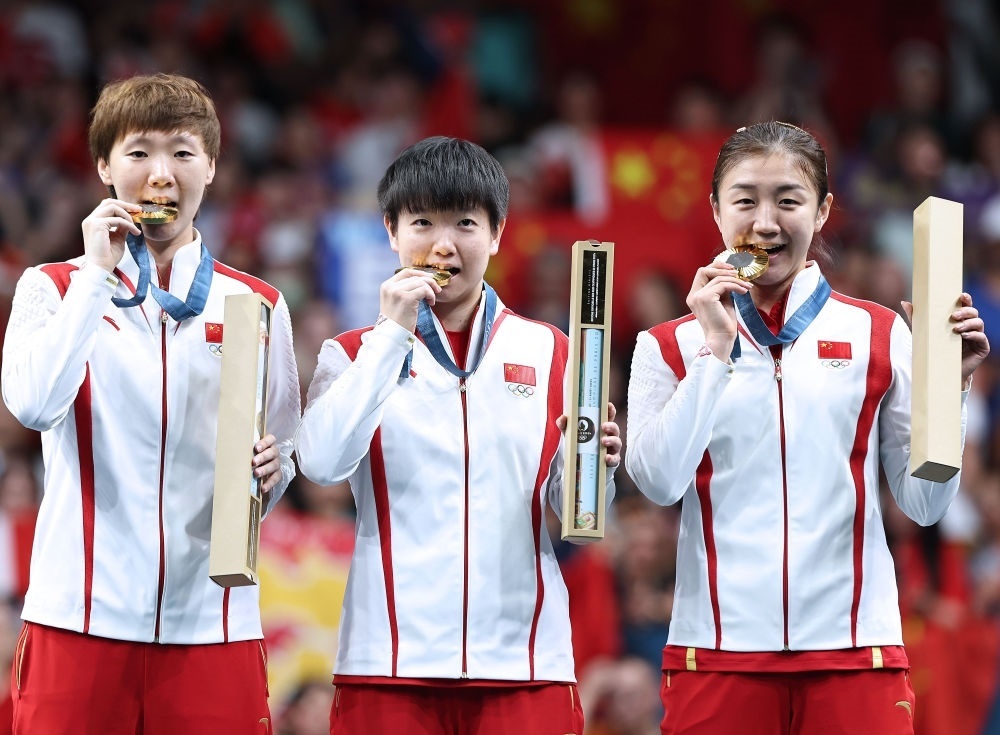 冠軍中國隊選手王曼昱、孫穎莎、陳夢（從左至右）在巴黎奧運會乒乓球女子團體頒獎儀式上（2024年8月10日攝）。新華社記者 王東震 攝