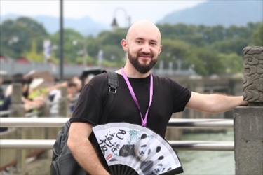 俄羅斯塔斯社執(zhí)行編輯葉夫根尼·扎多羅日內(nèi)在都江堰魚(yú)嘴拍照留念。（李佩藺 攝）