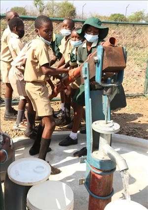 △2021年11月，在津巴布韋南馬塔貝萊蘭省省會(huì)關(guān)達(dá)的塞農(nóng)多小學(xué)，學(xué)生從中國(guó)援建水井里打水。