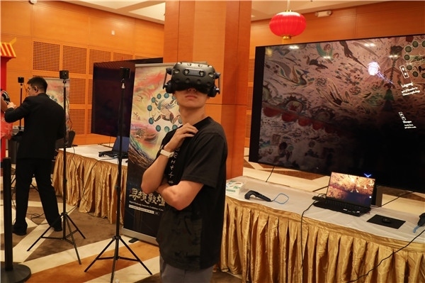 1、在本次活動的展覽現(xiàn)場，敦煌研究院與騰訊展示了“數(shù)字藏經(jīng)洞”和“尋境敦煌”等創(chuàng)新互動產(chǎn)品。圖為當?shù)孛癖娡ㄟ^VR虛擬游覽洞窟。 人民網(wǎng)記者 李志偉攝