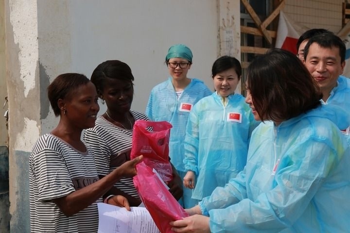 2015年4月4日，在位于塞拉利昂首都弗里敦市郊的中塞友好醫(yī)院埃博拉診療中心，中國第四批援塞醫(yī)療隊副隊長邵蔚（右前）向被治愈的埃博拉出血熱患者贈送禮物。新華社發(fā)（祖榮強(qiáng) 攝）