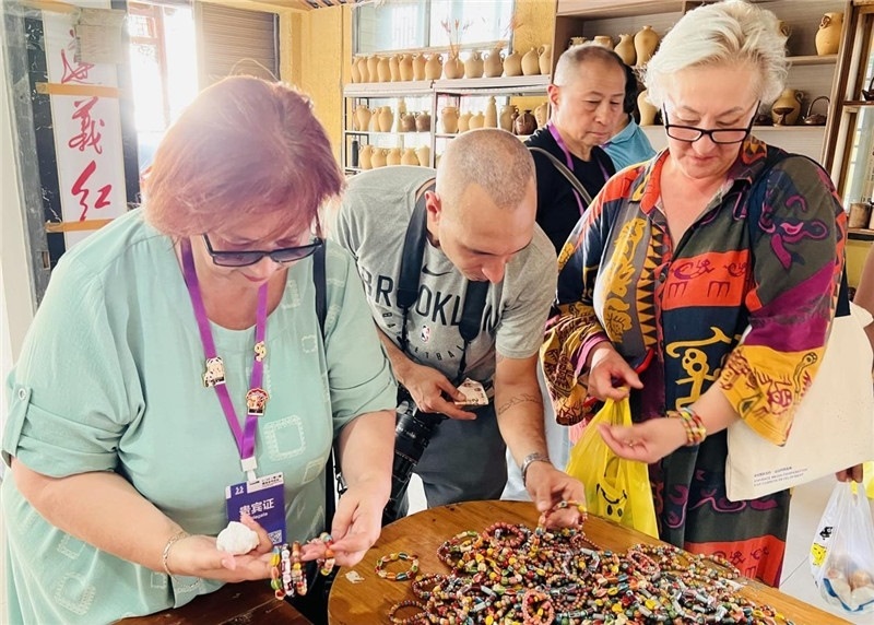 歐亞媒體考察團(tuán)成員在母氏陶藝館內(nèi)挑花了眼，色彩絢麗、質(zhì)地均勻的陶藝手串讓他們愛不釋手?！斑@里的東西都太實(shí)惠了！”塔吉克斯坦《索格特真理報(bào)》政論部主任娜塔利婭·多羅費(fèi)耶娃說?；宓奶厣a(chǎn)品物美價(jià)廉，讓考察團(tuán)成員為家人好友買到了心儀的禮物，也為此次以四川成都為起點(diǎn)，路經(jīng)南充、廣安至貴州遵義的考察行程畫上了圓滿句號(hào)。（張亞欣攝）