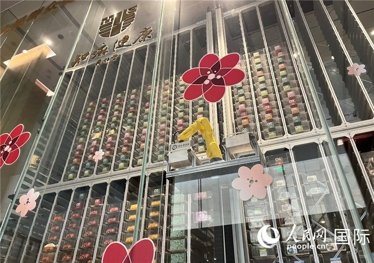 6. 機(jī)械臂正在取貨。（人民網(wǎng)記者陳思 攝）