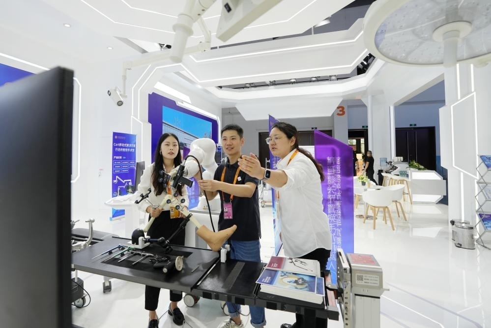 9月11日，一位媒體記者（中）在2024年服貿(mào)會國家會議中心會場體驗北京納通科技集團有限公司的膝關(guān)節(jié)置換手術(shù)機器人。新華社記者鞠煥宗 攝