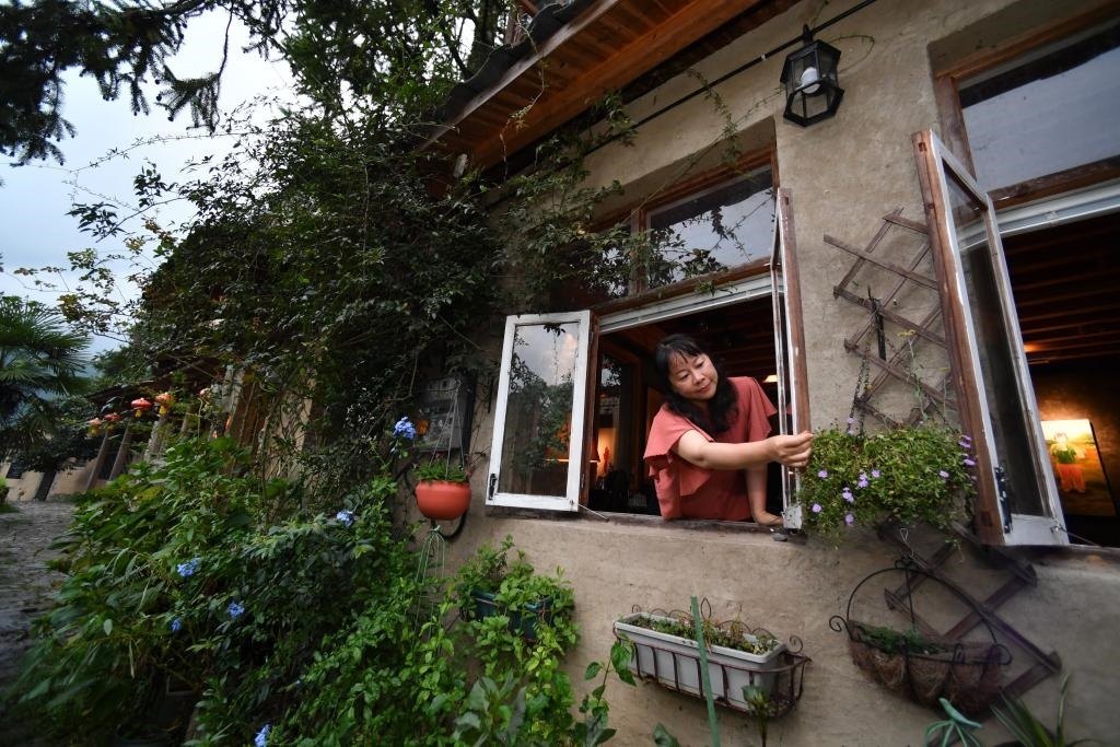 8月29日，在福建省屏南縣熙嶺鄉(xiāng)，龍?zhí)洞濉靶麓迕瘛泵泛暝诖蚶碜约航?jīng)營(yíng)的民宿外墻裝飾花盆。新華社記者姜克紅 攝