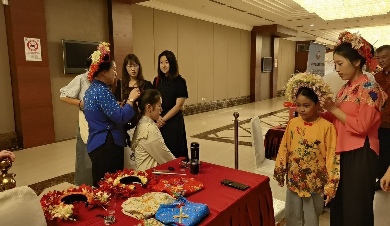 阿拉扎大學(xué)孔子學(xué)院志愿者老師向傳承人學(xué)習(xí)簪花圍。阿拉扎大學(xué)孔子學(xué)院供圖