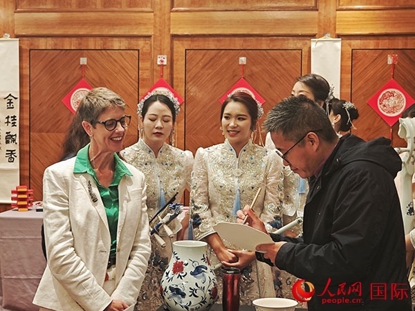 現(xiàn)場(chǎng)的非遺傳承人為英國(guó)觀眾展示畫技。人民網(wǎng)記者 邢雪攝