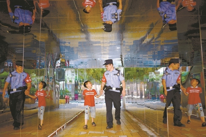 ?7月16日，重慶市公安局江北區(qū)分局一名民警在巡邏途中遇到一個(gè)獨(dú)自玩耍的小男孩，民警將其送回家。王洪平攝