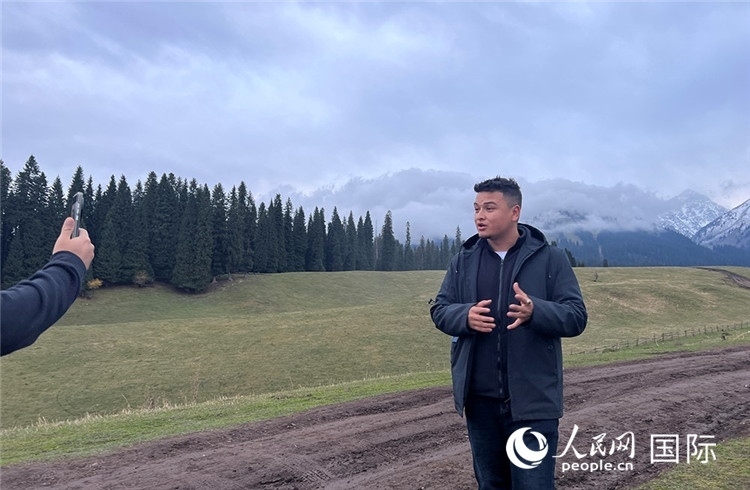 在庫爾德寧，吾買爾江被雪山美景震撼，即興錄制了短視頻作品。人民網(wǎng)記者曾書柔攝