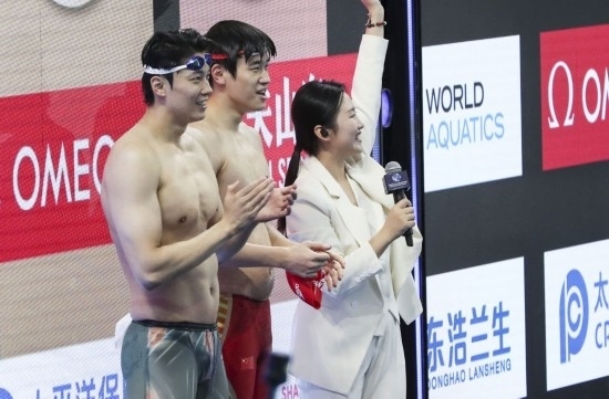  10月18日，汪順（左）和潘展樂在男子100米混合泳決賽后。新華社記者 方喆 攝