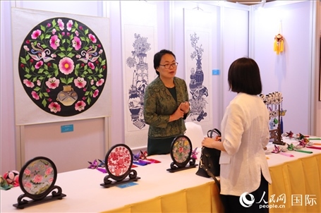 青海非遺文化傳承人向嘉賓介紹展品。人民網(wǎng)實習(xí)生姚欣可攝