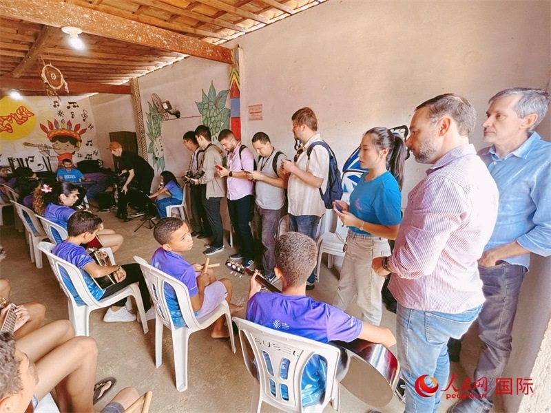  受益于中國企業(yè)的“青少年成長”項目，700多名當?shù)厍嗌倌甑囊魳泛妥闱驂粝氩迳狭顺岚?。圖為聯(lián)合采訪團正在采訪參加音樂培訓的孩子們。 人民網(wǎng)記者 陳一鳴攝