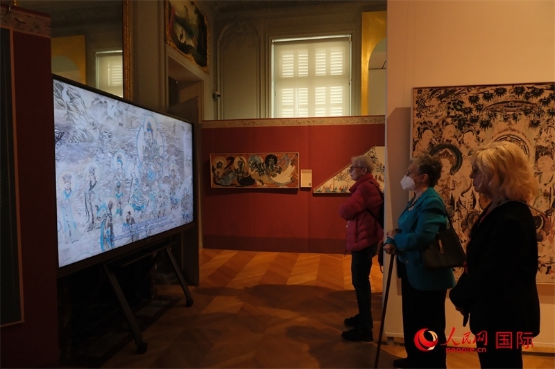 觀眾在展臺(tái)觀看錄像講解。人民網(wǎng)記者 尚凱元攝