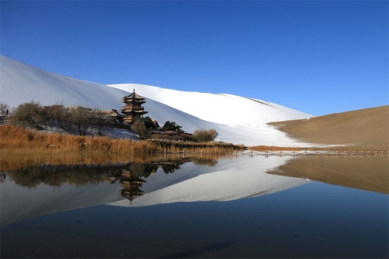 鳴沙山月牙泉景區(qū)雪景。敦煌市委宣傳部供圖，張曉亮攝