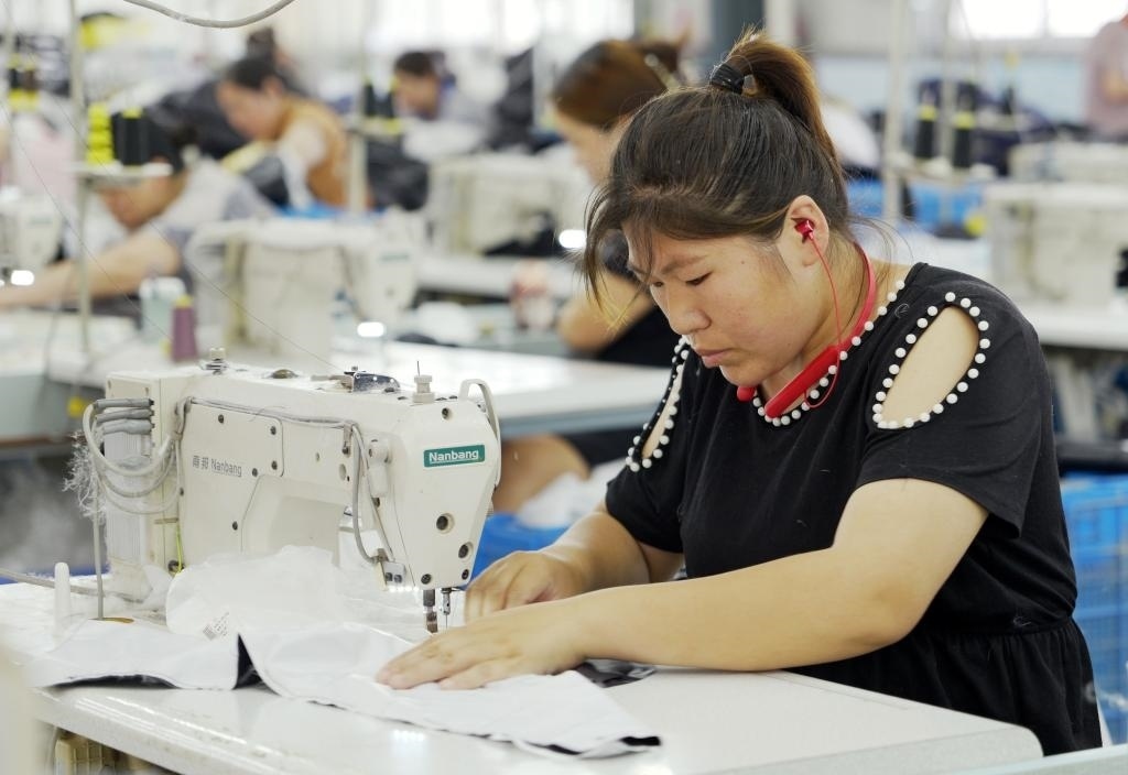 5月20日，村民在李寨村服裝加工廠內(nèi)忙碌。河南省周口市沈丘縣馮營(yíng)鎮(zhèn)李寨村地處豫東平原。近年來(lái)，乘著脫貧攻堅(jiān)與鄉(xiāng)村振興政策的東風(fēng)，李寨村積極探索產(chǎn)業(yè)發(fā)展模式，通過(guò)“龍頭企業(yè)+村集體經(jīng)濟(jì)+農(nóng)戶(hù)”的方式，逐漸發(fā)展形成肉牛養(yǎng)殖、設(shè)施農(nóng)業(yè)、服裝加工、康養(yǎng)民宿等產(chǎn)業(yè)，以產(chǎn)業(yè)振興助力鄉(xiāng)村振興。新華社記者 李嘉南 攝