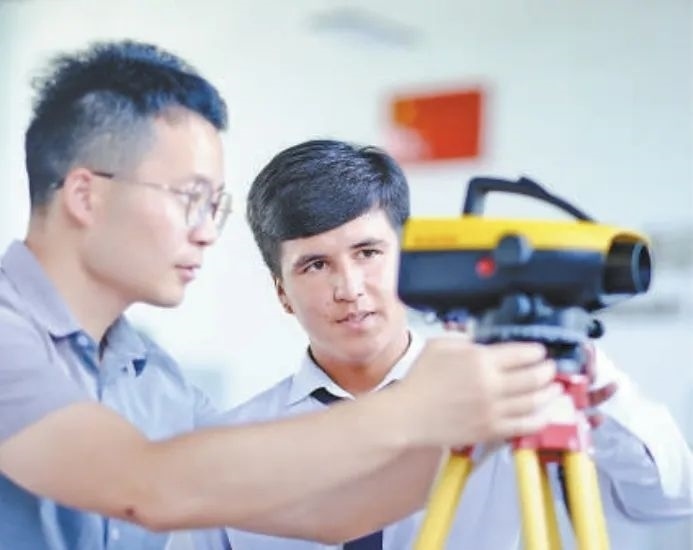 在塔吉克斯坦首都杜尚別的魯班工坊，來自天津城市建設管理職業(yè)技術學院的老師（左）為當?shù)貙W生提供指導。新華社記者 鄭開君 攝