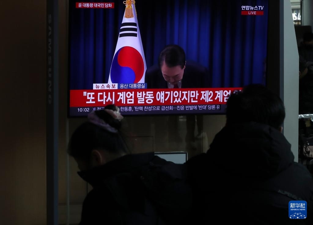 12月7日，在韓國首爾火車站，民眾觀看總統(tǒng)尹錫悅發(fā)表講話的電視畫面。新華社記者 姚琪琳 攝