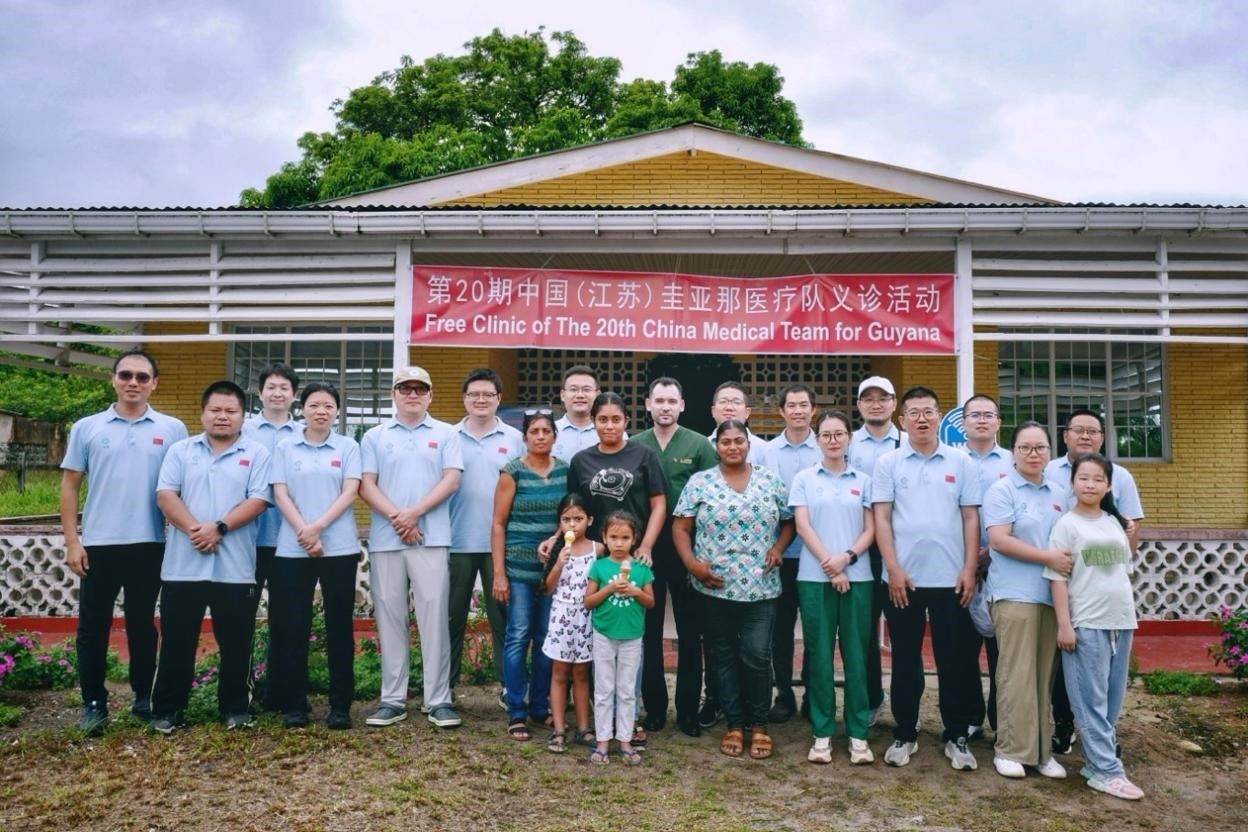 第20期中國(guó)（江蘇）援圭亞那醫(yī)療隊(duì)在圭偏遠(yuǎn)的林登高速社區(qū)開(kāi)展義診后，與部分當(dāng)?shù)鼐用窈嫌啊?中國(guó)援圭醫(yī)療隊(duì)供圖
