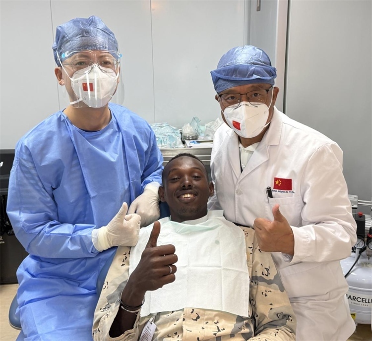 援吉醫(yī)療隊口腔科王瑋主任與“和平方舟”號醫(yī)院船醫(yī)務(wù)人員共同為一名當(dāng)?shù)匮浪柩谆颊咴\療。中國（山西）第23批援吉布提醫(yī)療隊供圖