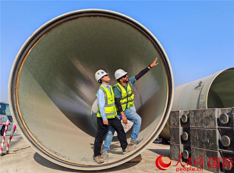 工作人員在察看輸水管情況。人民網(wǎng)記者 管克江攝