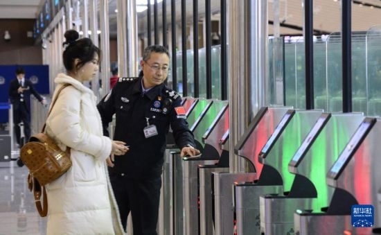 1月2日，大興機場邊檢站警察指導(dǎo)旅客使用自助出境設(shè)備。新華社記者 李欣 攝