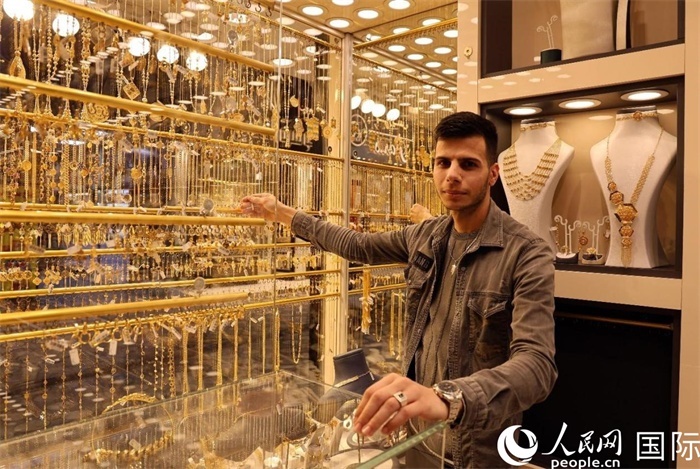 一名銷售員展示黃金飾品。人民網(wǎng) 伊納斯·易卜拉欣攝