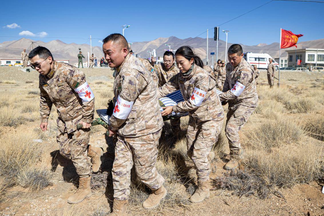 1月9日，日喀則定日縣長所鄉(xiāng)，西藏軍區(qū)總醫(yī)院醫(yī)療隊隊員將受傷村民用擔(dān)架從救護車準(zhǔn)備抬上直升機，轉(zhuǎn)運至拉薩的西藏軍區(qū)總醫(yī)院救治。人民日報記者張武軍攝