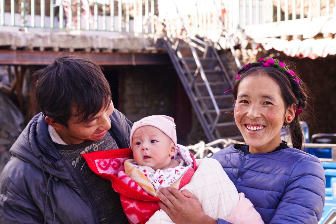 1月11日，在西藏日喀則市人民醫(yī)院，受災(zāi)群眾抱著自己在地震中受傷的孩子康復(fù)出院。人民日報記者徐馭堯攝